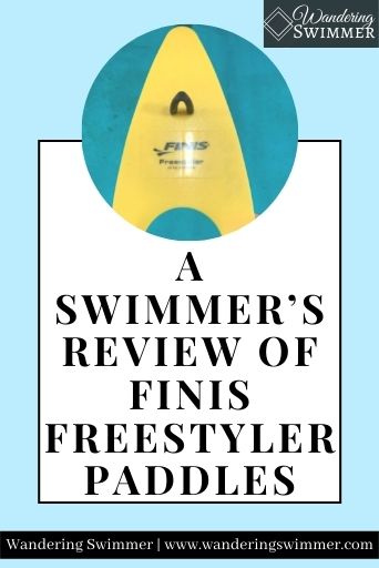 Image with a pale blue background. A circle shape has a picture of a yellow FINIS Freestyler Paddle. Below that is a white text box with a black border. Black text reads: A Swimmer's Review of FINIS Freestyler Paddles.