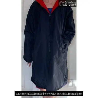 Image of a personwearing an a dark navy and red Adoretex swim parka. It's zipped to show how it fits when closed, along with the length of the sleeves and parka on the legs