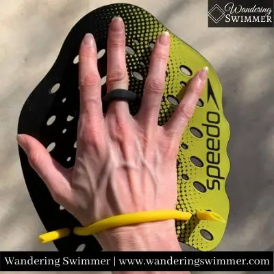 Picture of a right hand in a yellow Speedo Power Paddle Plus paddle. 